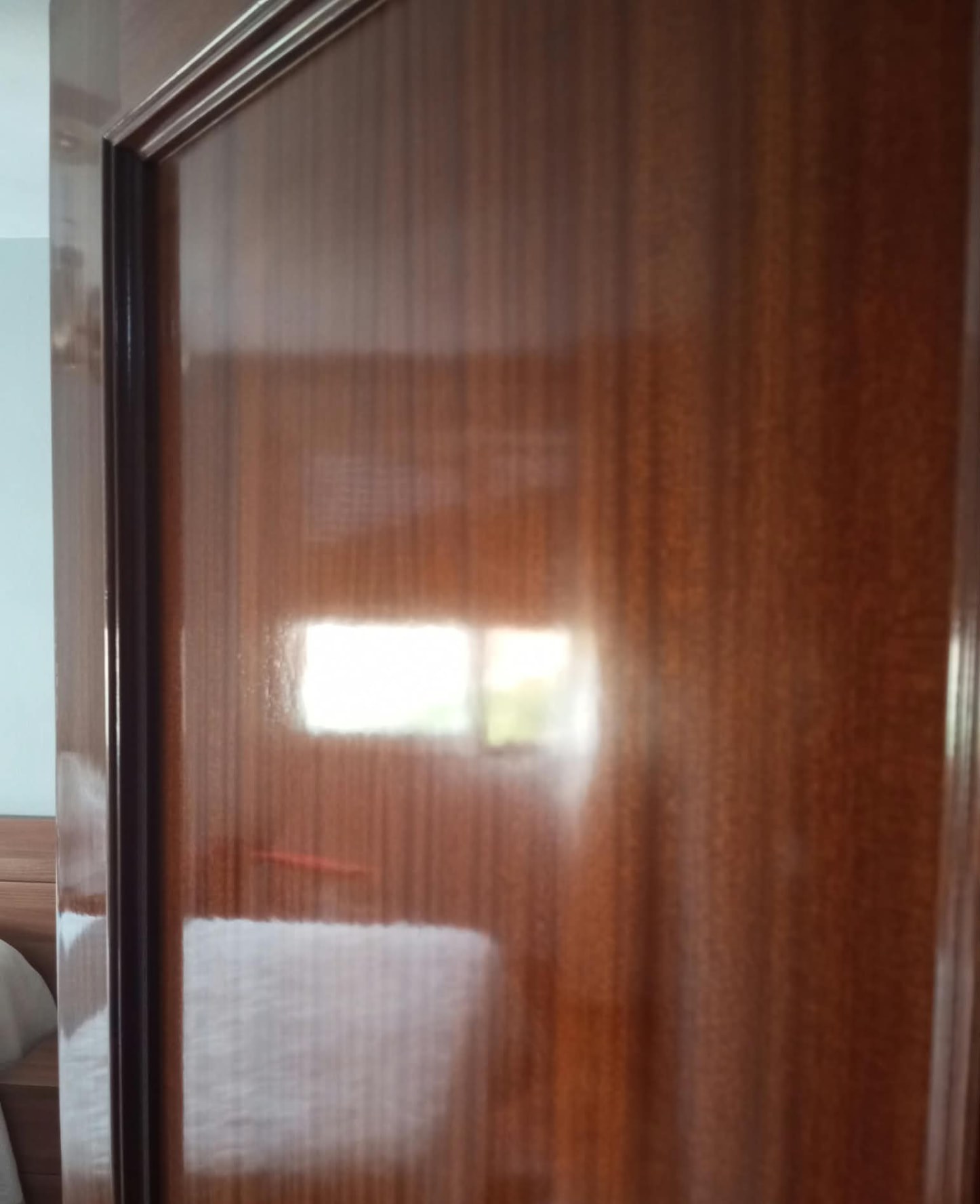 Detalle de puerta de madera con acabado de barniz brillante
