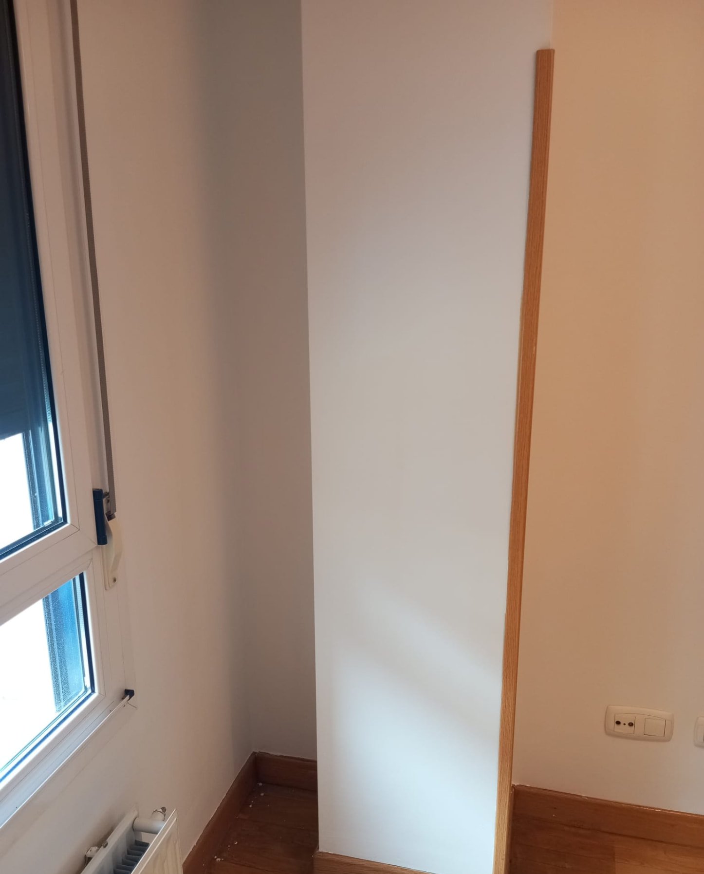 Habitación con ventana y paredes pintadas en blanco
