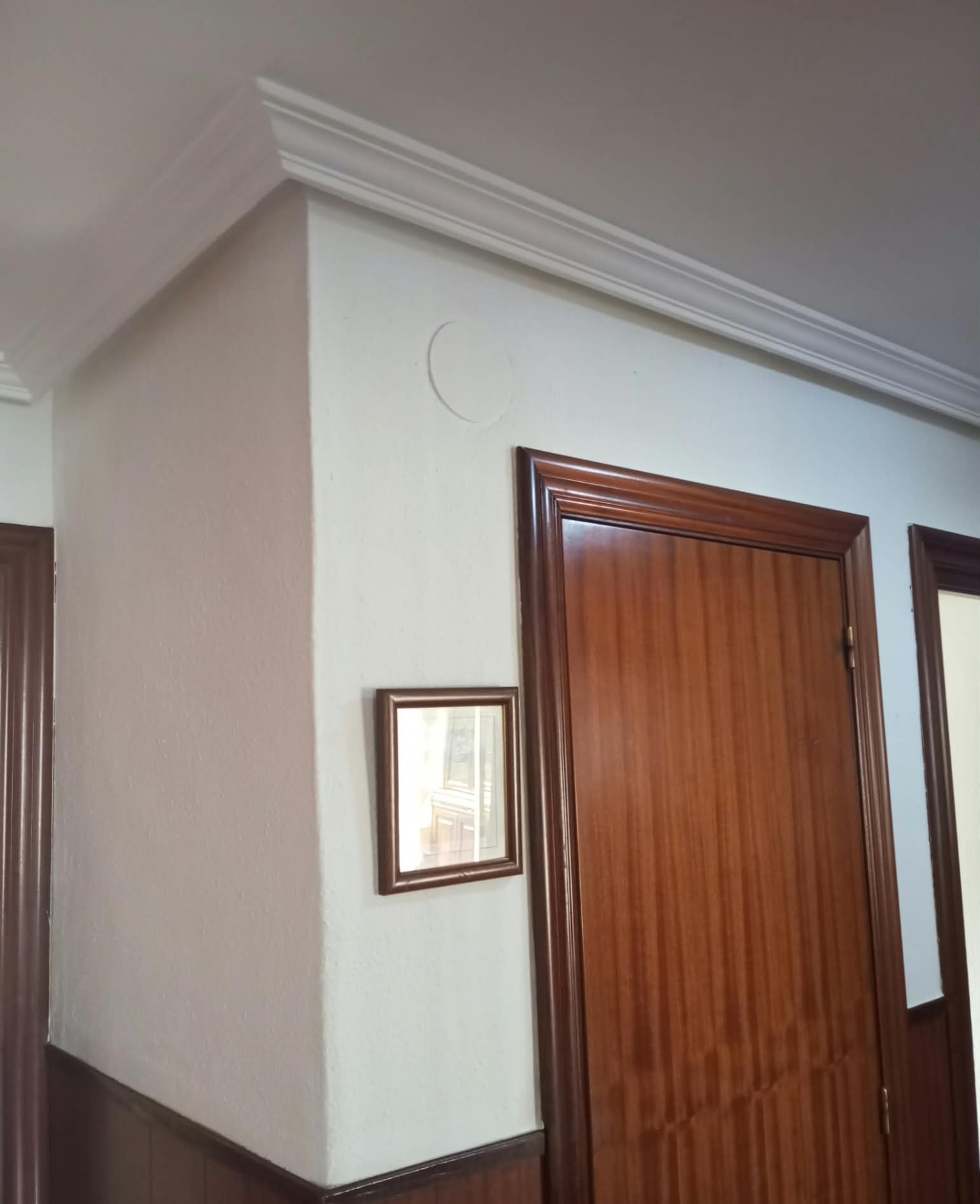Distribuidor pintado en blanco con molduras y carpintería de madera