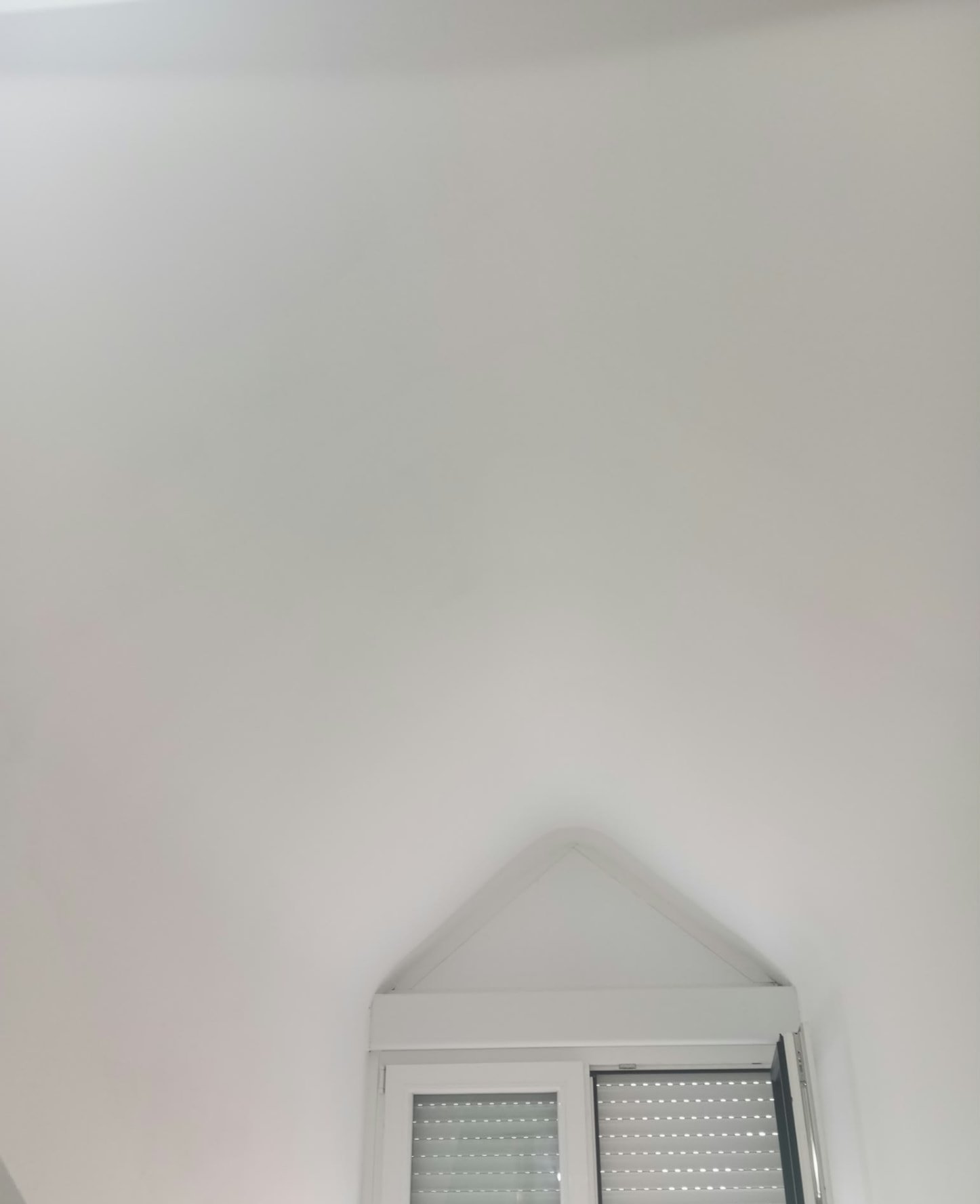 Techo y hueco de ventana triangular pintados en blanco