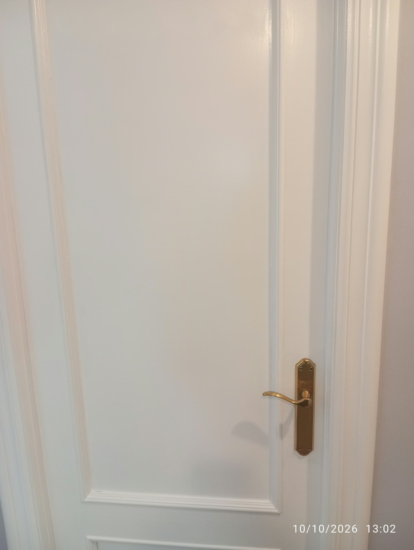 Puerta de madera lacada en blanco con marcos y molduras