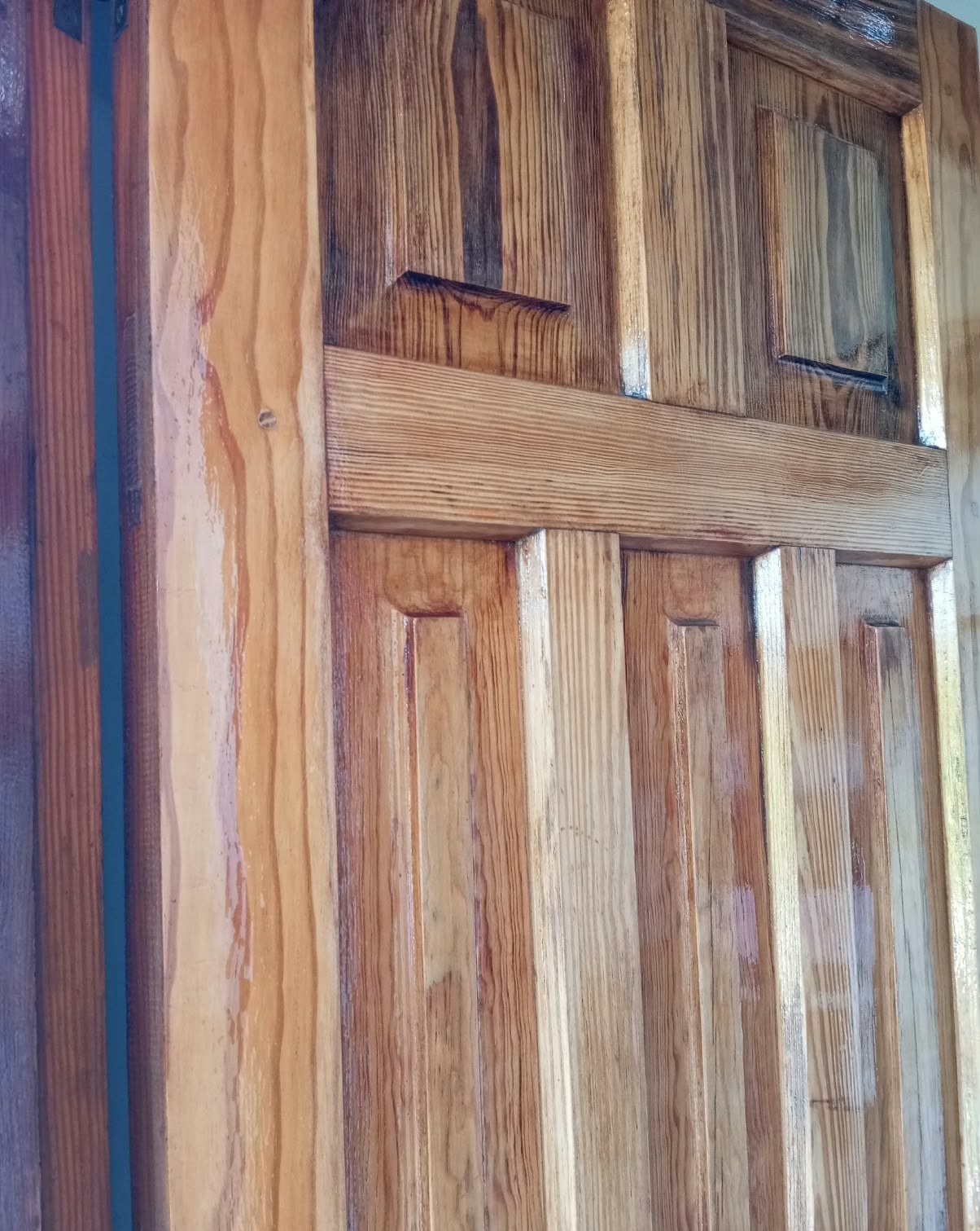 Detalle de puerta de madera barnizada con tableros