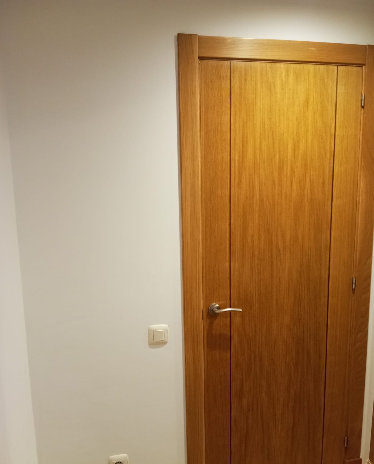 Puerta doble de madera con paredes pintadas en tonos claros