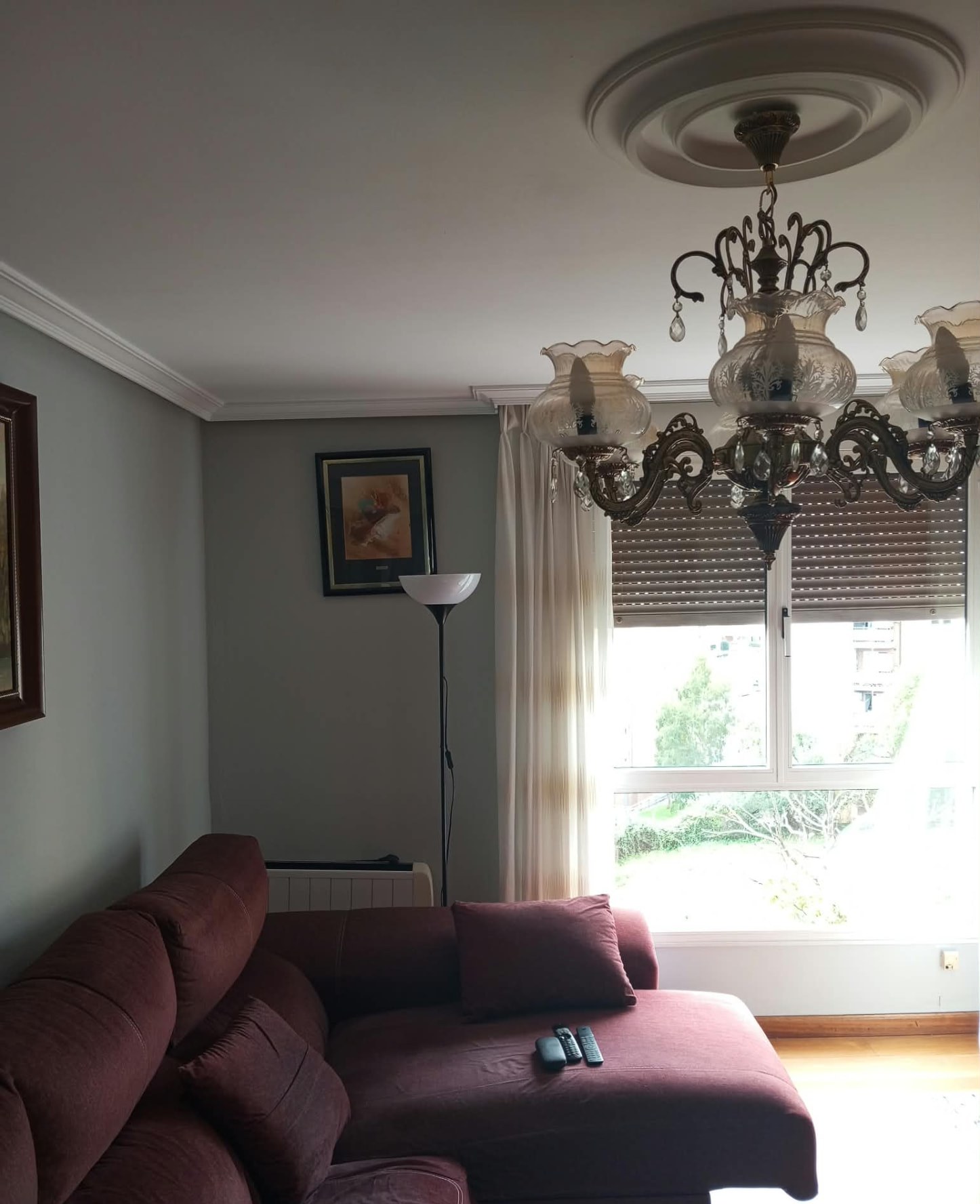 Salón pintado en gris con molduras blancas y gran ventanal