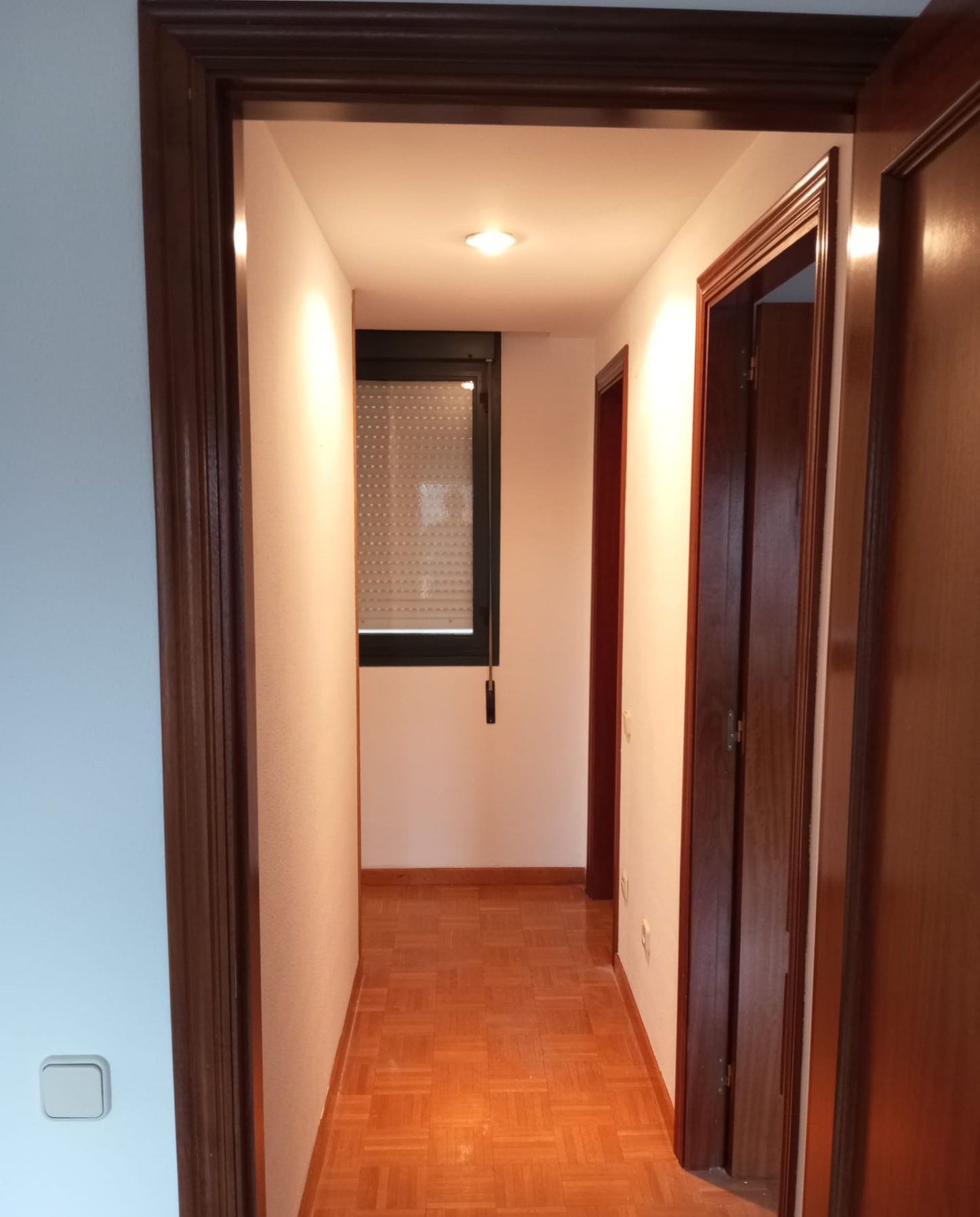Pasillo con ventana pintado en tonos claros