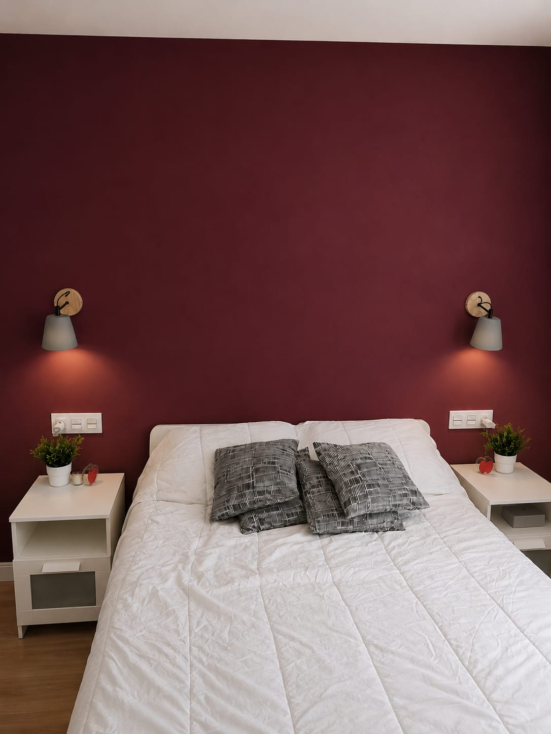 Dormitorio con pared de cabecero pintada en color burdeos