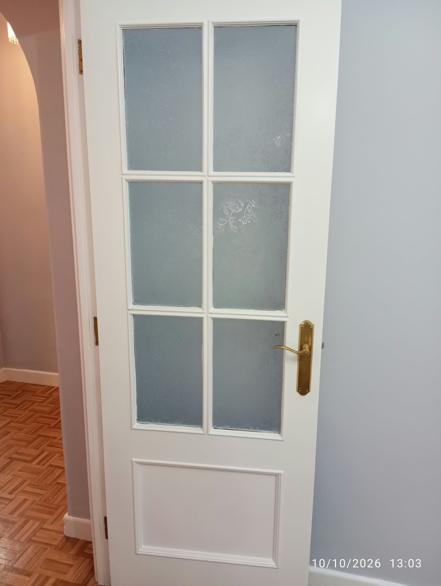 Puerta lacada en blanco con cristal esmerilado y manilla dorada