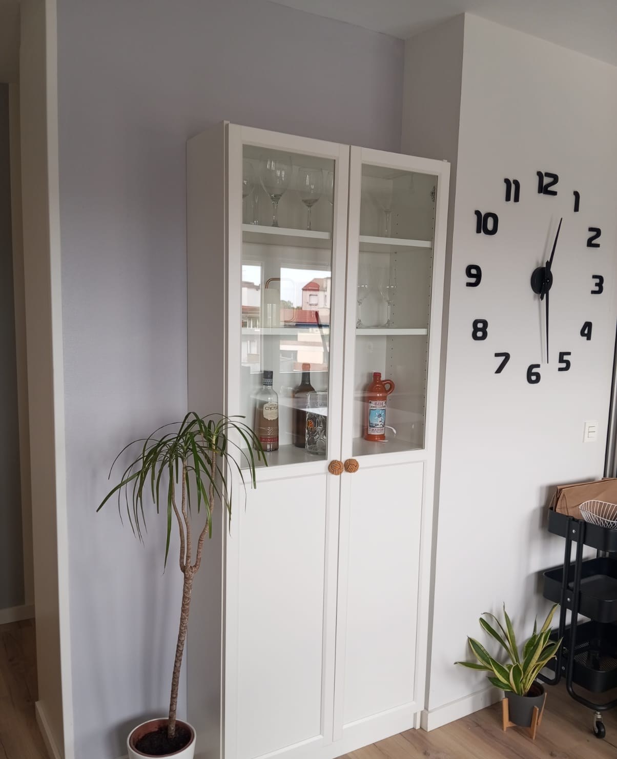 Salón con pared gris lila y vitrina blanca