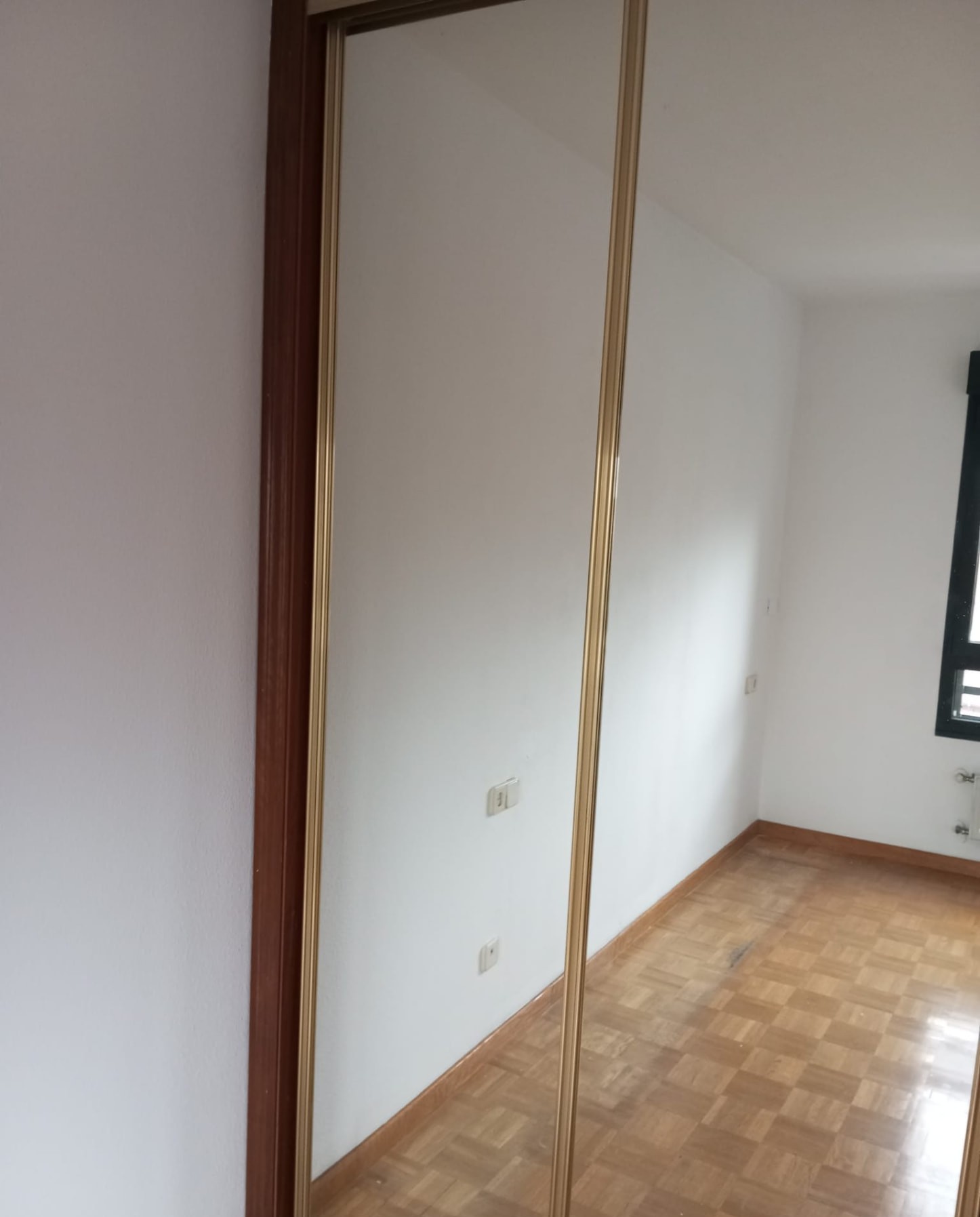 Dormitorio con paredes blancas recién pintadas y armario corredero