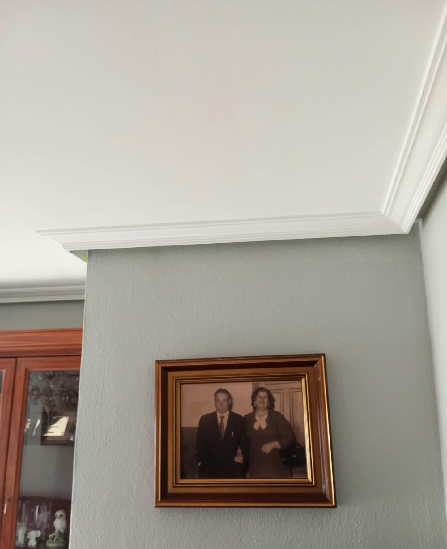 Detalle de pared gris y molduras de techo pintadas en blanco