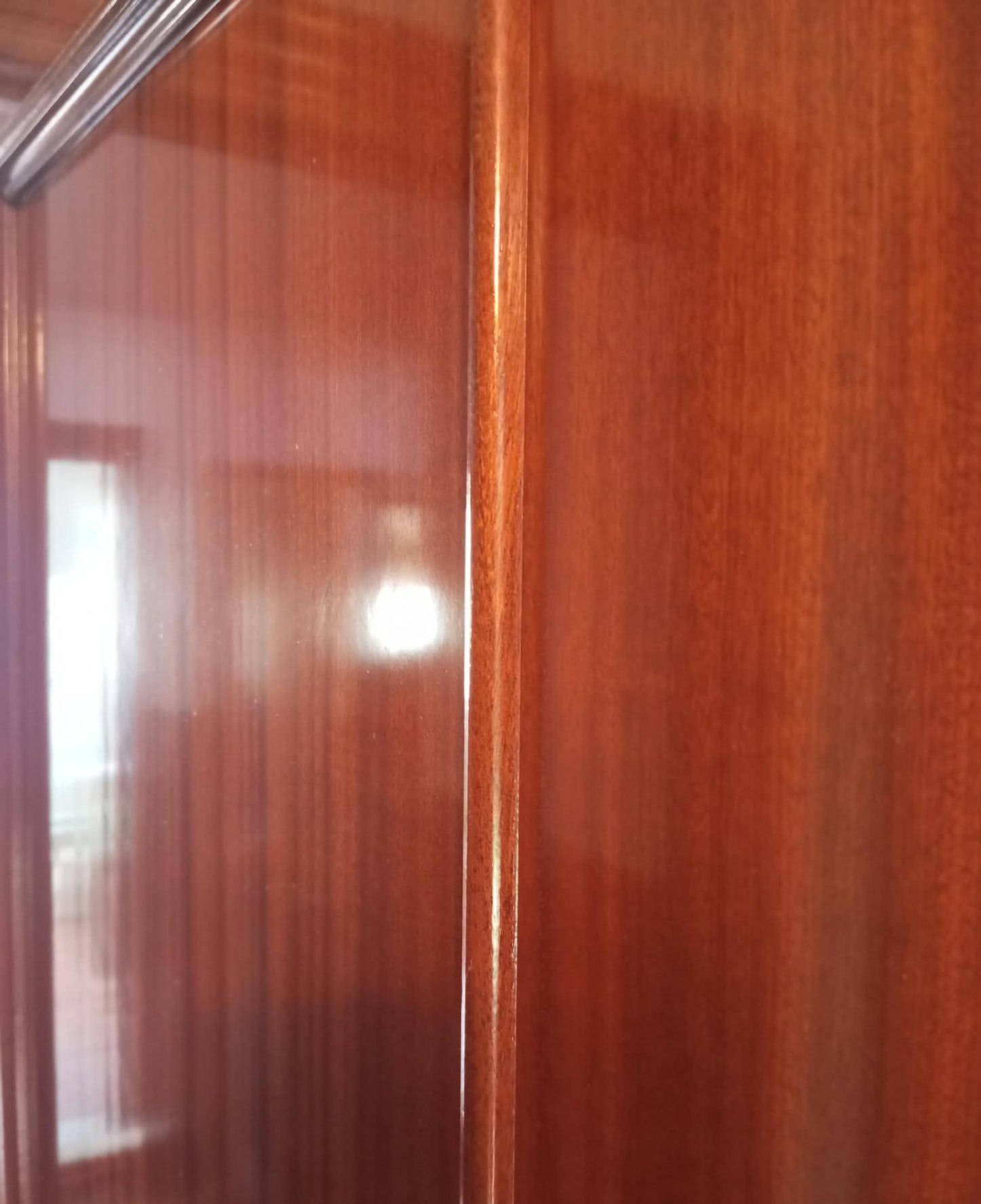 Detalle del acabado brillante de un armario de madera barnizado